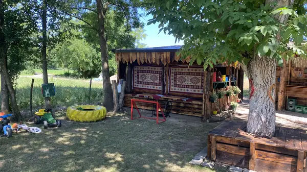 Igralište i drvena klupa u hladu drveta u dvorištu Denić Raja