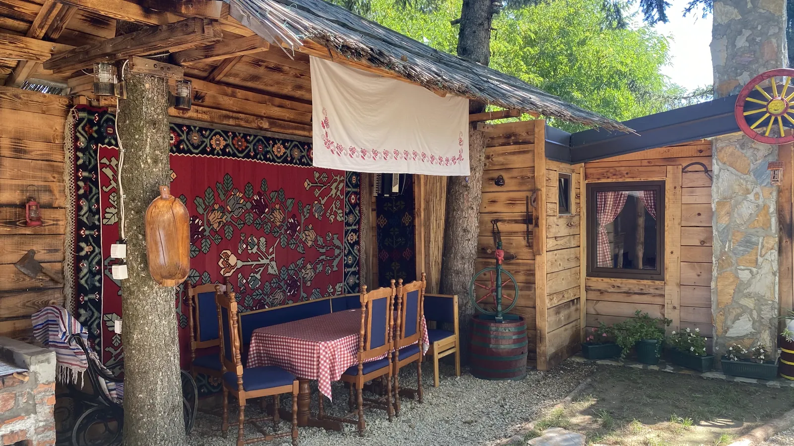 Natkriveni prostor za sedenje sa etno ćilimom na zidu